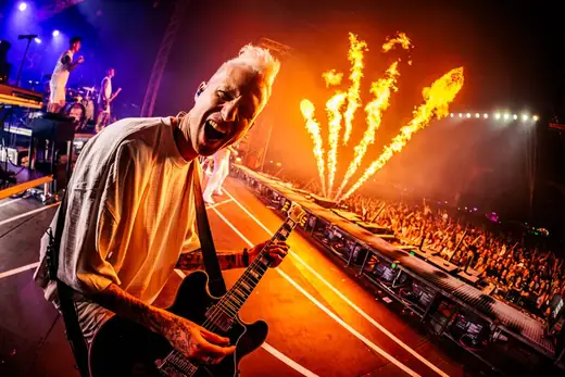 Gitarist van The Dirty Daddies voor een vuurzuil